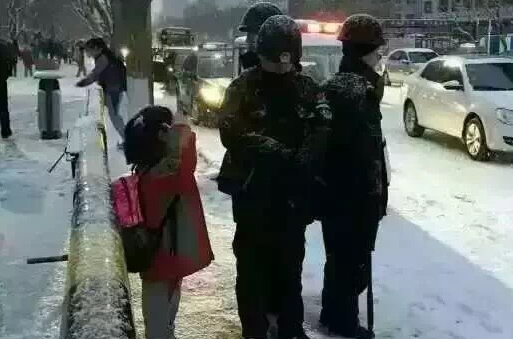 小朋友向雪地中站岗警察叔叔敬礼