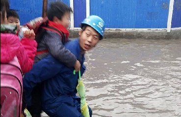 暖心！3位工人背百名小学生趟水进校园