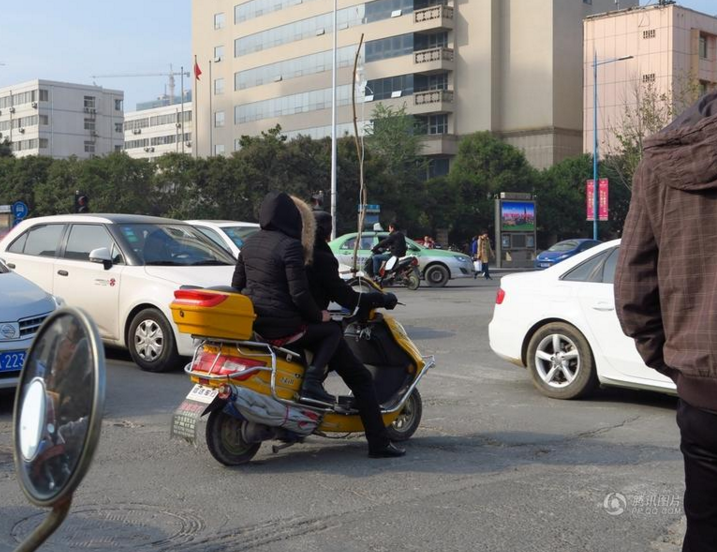 郑州街头现奇葩病人 男子骑电动车输液