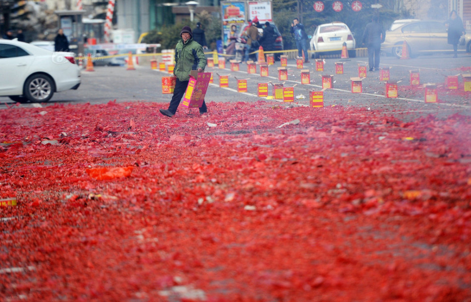 2月14日，山东济南，春节假期后上班第一天，很多商家习惯性的放起了“开门炮”，寓意新年红红火火。在当地一商场门前，数百挂鞭炮和高空礼花同时点燃，顿时硝烟四起，鞭炮炸响声震耳欲聋，遍地都是红色鞭炮纸屑，在污染环境的同时也加重了环卫工人的负担。
