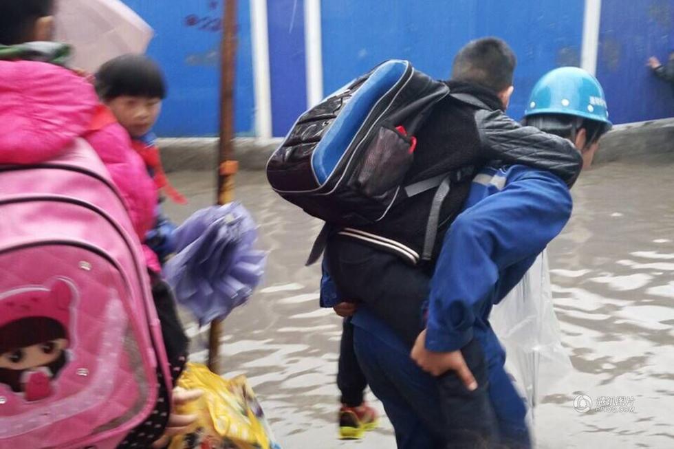 　　李女士32岁，儿子在硚口区红旗村小学读二年级。她说，今日早上送儿子上学时，发现学校大门口附近，10来米的路段积水近20公分，完全没法步行通过。就在她着急如何让孩子到学校时，一名戴着“中铁隧道”字样安全帽的工人上前，主动说可以把她的儿子背到学校门口。