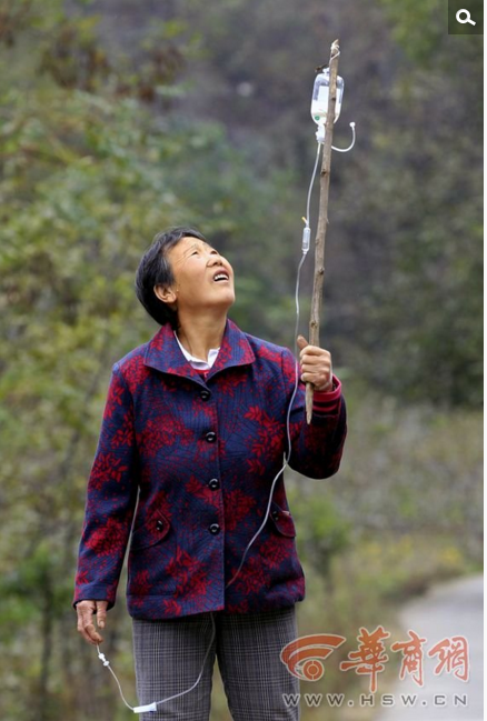 　　“我们这里相对贫困，那个时候由‘血头’通知卖血的人，然后组织大伙到商洛、西安、甘肃等地卖血。”王侃良和妻子丁彩凤卖血时还是身体强壮的年轻人，他们回忆，当时一个村子，一传十十传百，大家分批分期去卖血，几乎每个礼拜，村子都有人去卖血，一个人一次抽血300毫升就能挣到36元，一些村民由于挣钱没门路，就将卖血当成了主要家庭收入。这种疯狂的卖血行为到了上世纪九十年代后，才逐渐停息下来，这些卖血者也陆续回到村上，那时就有人感染上了丙肝，只是没有引起足够重视图为10月10日，南湾村，身患丙肝的丁恨恨边走边打吊瓶。