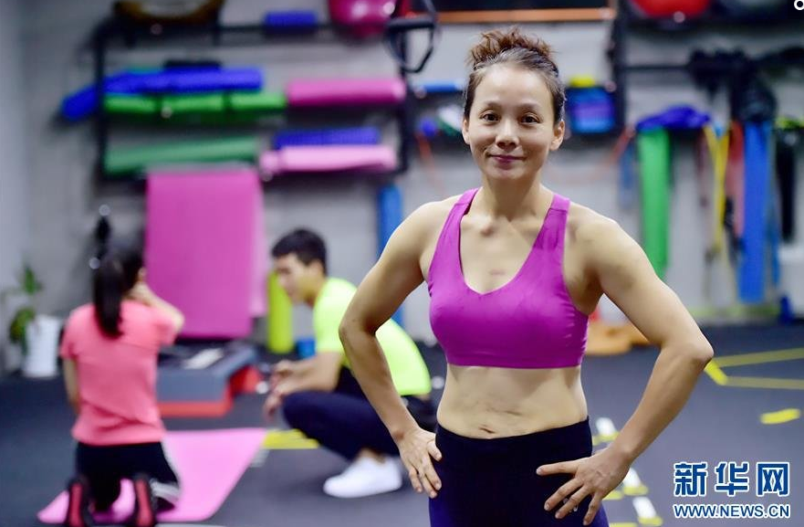 “健美大妈”吴菲在健身馆里准备进行赛前训练（10月12日摄）。在福州举行的2016年海峡两岸健美健身公开赛上，200多名健美高手同台竞技，这其中，50岁的“健美大妈”吴菲吸引了不少人的目光。吴菲从2014年开始练习竞技钢管舞。“我以前当过瑜伽教练，有舞蹈基础，因为喜欢挑战高难度的项目，就特别想尝试钢管舞项目。”她利用空余时间勤学苦练，功夫不负有心人，2014年至2016年，吴菲连续三年获得全国钢管舞锦标赛中年组冠军，2015年在俄罗斯获得第七届亚太国际钢管舞锦标赛国际中年组冠军。
