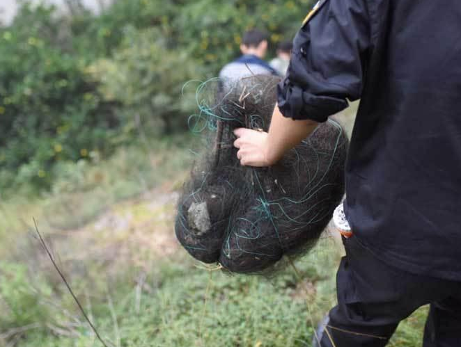 　　浙江嘉兴，当地派出所的护鸟员将残网收集带下山。