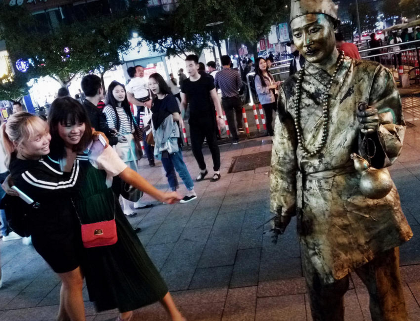 　　围观美女逗小伙笑，以此试探小伙的“功力”。