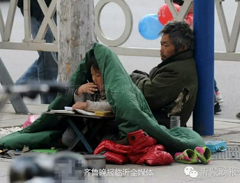 　　湿冷的临沂街头上，六岁女孩季红红正裹着被子在寒风中认真地写作业。他的家人在一旁乞讨。