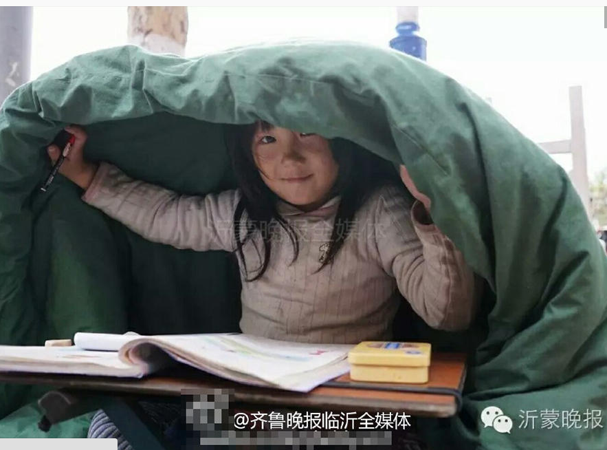 　　在寒风中顶着被子写作业的季红红，在寒风中面对镜头她依然露出了笑容。