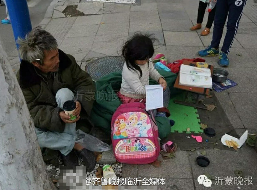 　　跟随家人在街头乞讨的季红红。在附近打扫卫生的环卫工人说，这个小女孩昨天就过来了，旁边一个头发花白的男子可能是她爸爸。