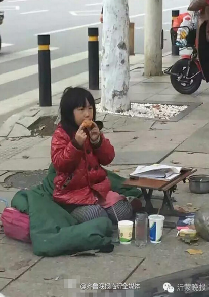　　季红红的面前摆放了一张供她写作业用的简易小桌子，以及路过的好心市民给她买的食物。