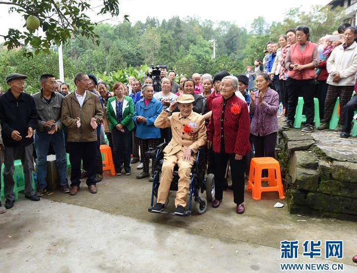 　　10月25日是抗美援朝66周年纪念日，当天在重庆忠县双桂镇石宝村举行了一场迟到了66年的婚礼，婚礼的主角是83岁的志愿军老战士古臣坤和他81岁的老伴何光英。图为10月25日，前来参加婚礼的乡亲们向新郎古臣坤和新娘何光英表达祝福。