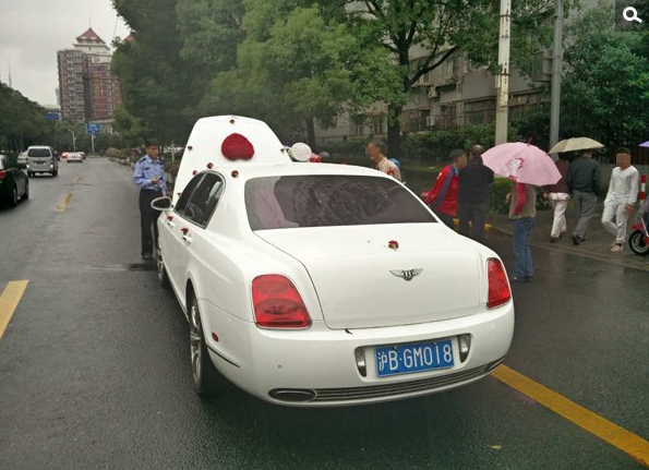 　　下午2点45分许，上海交警总队机动支队巡逻时，在周家嘴路近大连路处发现一路婚车车队，共计5辆车，其中领头的是悬挂“沪BGM018”牌号的白色宾利欧陆跑车。后经查实，此车为套牌车。