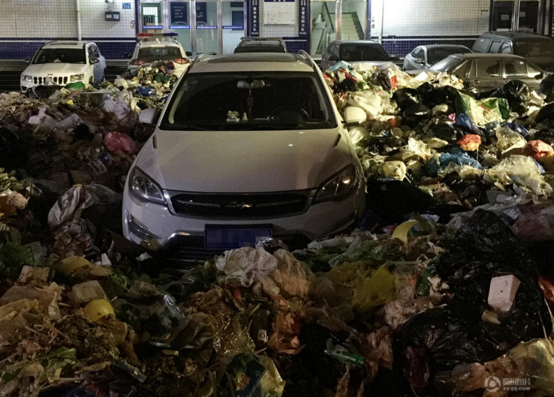 　　郑州市老城区布厂街环卫中转站前，一辆SUV轿车被数十吨生活垃圾团团包围。据车主尚先生称，当晚8时许，他和朋友去附近吃饭，顺手将车停在路边，没注意恰好挡在环卫中转站门前，等两人10点多吃饭回来开车时，顿时懵了，眼前一二百平方的垃圾将车团团包围，根本无法靠近。