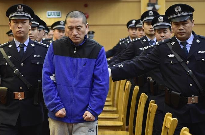 　　图为11月9日，瑞海公司董事长于学伟（中）在法警的带领下进入法庭。