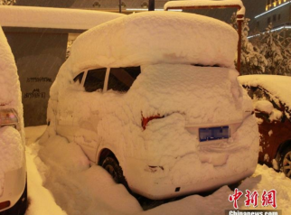 新疆阿勒泰迎持续暴雪 街头车辆被雪埋