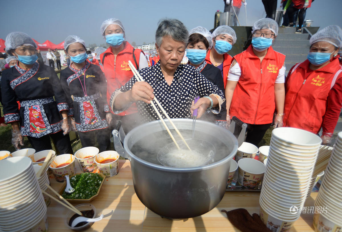 “栖凤渡鱼粉手工制作技艺”项目第三代传承人吴安英在节会现场为游客调制鱼粉。