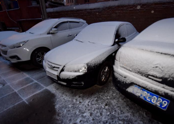 　　11月21日，北京迎今冬首场降雪，北京市气象台21日06时00分发布寒潮蓝色预警信号，受强冷空气影响，21-23日北京地区最低气温降幅达8～10℃。图为小区内的汽车被白雪覆盖。