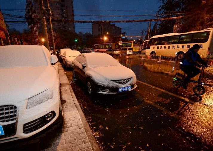 　　11月21日，北京迎今冬首场降雪，北京市气象台21日06时00分发布寒潮蓝色预警信号，受强冷空气影响，21-23日北京地区最低气温降幅达8～10℃。图为路边的汽车被白雪覆盖。