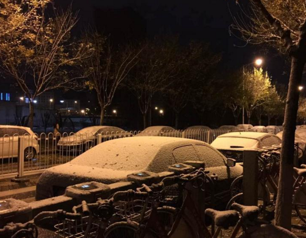 　　11月21日，北京迎今冬首场降雪，北京市气象台21日06时00分发布寒潮蓝色预警信号，受强冷空气影响，21-23日北京地区最低气温降幅达8～10℃。图为房山一小区外小车被裹上“银装”。